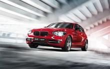 Ярко-красный BMW 1 серии проезжает по светлому тоннелю